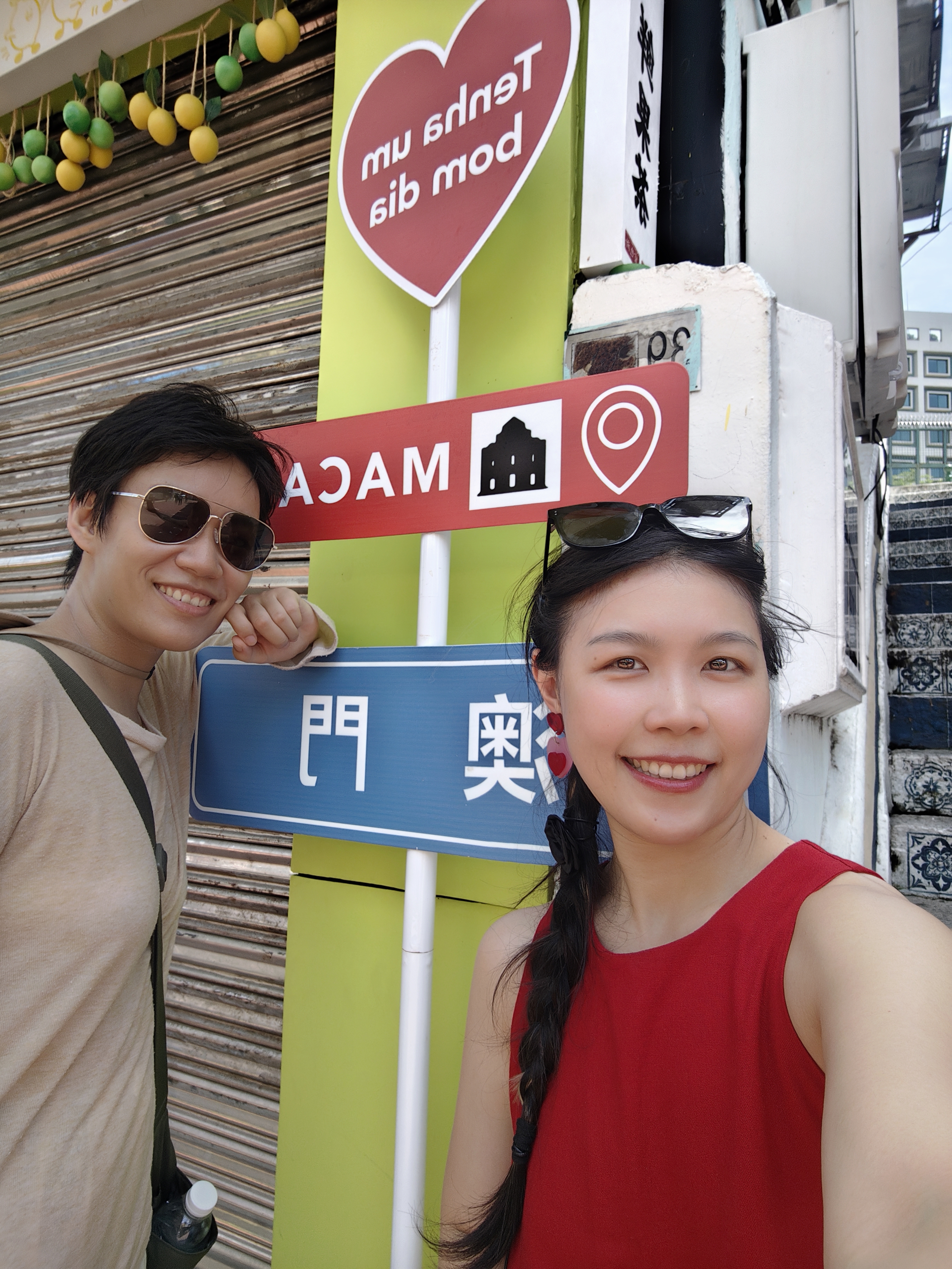 Cherish and Judy beside a Macau sign